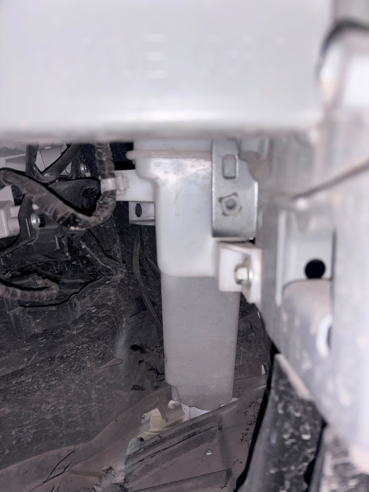 Detalle del depósito de limpiaparabrisas en el compartimento del motor